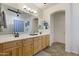 Bright bathroom featuring dual sinks, a large mirror, and a separate shower with glass block window at 4325 E Vallejo Ct, Gilbert, AZ 85298