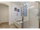 Bright bathroom featuring a soaking tub and glass enclosed shower with a view to a glass block window at 4325 E Vallejo Ct, Gilbert, AZ 85298