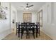 Bright dining room featuring a ceiling fan, plantation shutters, and a dark wood table with black chairs at 4325 E Vallejo Ct, Gilbert, AZ 85298