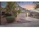 A cozy house exterior is shown with a driveway, landscape, and welcoming lighting at 4325 E Vallejo Ct, Gilbert, AZ 85298