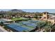 Aerial view showcasing the community tennis courts and recreation areas set against a picturesque mountain backdrop at 4325 E Vallejo Ct, Gilbert, AZ 85298