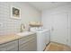 Bright laundry room featuring a sink with gold fixtures, butcher block countertop, and modern washer and dryer at 4331 E Avalon Dr, Phoenix, AZ 85018