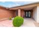 Charming brick home featuring a secure metal screen door and lush, well-manicured landscaping at 5022 E Magic Stone Dr, Phoenix, AZ 85044