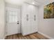 Hallway with entry door and built-in cabinets, plus attractive wood-look flooring and an art piece at 5022 E Magic Stone Dr, Phoenix, AZ 85044