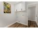 Convenient laundry room with white cabinets, wood-look flooring, and a decorative painting on the wall at 5022 E Magic Stone Dr, Phoenix, AZ 85044