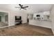 Open-concept living space with updated flooring, a modern ceiling fan, and a kitchen view at 5022 E Magic Stone Dr, Phoenix, AZ 85044
