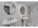 Modern bathroom featuring dual pedestal sinks, round mirrors, and a walk-in shower with decorative tile at 5110 E Verde Ln, Phoenix, AZ 85018