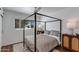 Bedroom showcasing a four-poster bed, neutral decor, and ample natural light from the window at 5110 E Verde Ln, Phoenix, AZ 85018