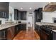 Modern kitchen featuring dark cabinetry, stainless steel appliances, granite countertops, and tiled flooring at 5110 E Verde Ln, Phoenix, AZ 85018