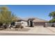 Well-manicured home exterior boasts a two-car garage, desert landscaping, and neutral color palette at 7024 W Tether Trl, Peoria, AZ 85383