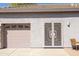 Home exterior featuring a two-car garage and a screened door at 7024 W Tether Trl, Peoria, AZ 85383