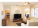 Open concept living room with tile floors, a large TV, and a neutral color palette at 7024 W Tether Trl, Peoria, AZ 85383