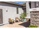 A charming patio area with seating and a decorative potted tree enhances this home's curb appeal at 7024 W Tether Trl, Peoria, AZ 85383