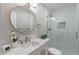 Modern bathroom with marble countertop, gold framed round mirror, and tiled shower at 7526 E Mckinley St, Scottsdale, AZ 85257