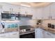 Modern kitchen featuring granite counters, subway tile backsplash, and stainless steel appliances at 7526 E Mckinley St, Scottsdale, AZ 85257