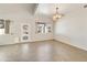 Spacious living area featuring a decorative light fixture, white walls, and tile flooring at 770 W Kent Pl, Chandler, AZ 85225