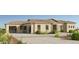 A modern, tan-colored home has a desert landscape, a tile roof, and a stone entryway, with a spacious driveway at 8233 E Camino Adele --, Scottsdale, AZ 85255