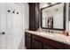 Bathroom vanity featuring dark wood cabinetry, granite countertops, and a sink; a large mirror reflects the closet at 8807 E Dahlia Dr, Scottsdale, AZ 85260
