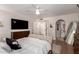 Bright bedroom featuring a large bed, mounted television, ceiling fan, and arched doorways for a cozy ambiance at 8807 E Dahlia Dr, Scottsdale, AZ 85260