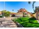 Charming two-story home with a red tile roof, a spacious driveway, and artificial grass at 8807 E Dahlia Dr, Scottsdale, AZ 85260