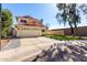 Charming two-story home with a red tile roof, a spacious driveway, and desert landscaping at 8807 E Dahlia Dr, Scottsdale, AZ 85260