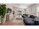 Bright living room with wood floors, a large couch, and a sliding glass door to the backyard at 8807 E Dahlia Dr, Scottsdale, AZ 85260
