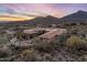 Aerial view of a luxurious home nestled in the desert landscape with a backdrop of mountains at 9920 E Honey Mesquite Dr # 155, Scottsdale, AZ 85262