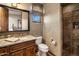 A bathroom showcasing a granite vanity, framed mirror, a glass-enclosed shower, and a window at 9920 E Honey Mesquite Dr # 155, Scottsdale, AZ 85262