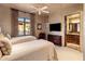 Bedroom with neutral color scheme, twin beds, ensuite bathroom access, and exterior views at 9920 E Honey Mesquite Dr # 155, Scottsdale, AZ 85262