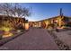 Long brick driveway leading to a stunning single-story home with desert landscaping at dusk at 9920 E Honey Mesquite Dr # 155, Scottsdale, AZ 85262