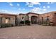 Stunning single-story home with an arched entrance, desert landscaping, and a brick driveway at 9920 E Honey Mesquite Dr # 155, Scottsdale, AZ 85262