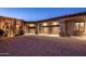 Beautiful three-car garage with desert landscaping and an expansive brick driveway at dusk at 9920 E Honey Mesquite Dr # 155, Scottsdale, AZ 85262