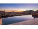 Gorgeous infinity pool overlooks the surrounding desert landscape as the sun sets in the distance at 9920 E Honey Mesquite Dr # 155, Scottsdale, AZ 85262
