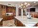 Charming kitchen featuring custom wood cabinets, center island, and elegant chandelier at 9920 E Honey Mesquite Dr # 155, Scottsdale, AZ 85262