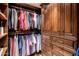 This walk-in closet features custom dark wood cabinetry and shelving for optimal storage and organization at 9920 E Honey Mesquite Dr # 155, Scottsdale, AZ 85262