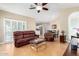 Bright living room with hardwood floors, large windows, comfortable seating, and ceiling fan at 10155 E Bella Vista Dr, Scottsdale, AZ 85258