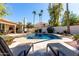 Backyard pool with lounge chairs, lush landscaping, and blue skies at 10155 E Bella Vista Dr, Scottsdale, AZ 85258