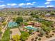 An aerial shot of a property, highlighting the pool, tennis court, and sand volleyball court at 10290 N 117Th Pl, Scottsdale, AZ 85259