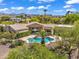 Aerial view of the backyard oasis featuring a sparkling pool surrounded by lush greenery and serene mountain views at 10290 N 117Th Pl, Scottsdale, AZ 85259
