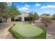 Backyard features a private putting green, perfect for golf enthusiasts, with desert landscaping at 10290 N 117Th Pl, Scottsdale, AZ 85259
