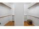 Spacious walk-in closet featuring custom shelving and wooden floors at 10290 N 117Th Pl, Scottsdale, AZ 85259