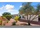 Well-manicured backyard with drought-resistant landscaping and a covered back patio in the distance at 12860 W Junipero Dr, Sun City West, AZ 85375