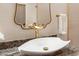 Close-up of elegant vanity with gold faucet and granite countertop at 12860 W Junipero Dr, Sun City West, AZ 85375