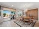 Light filled dining room with patio access, light wood floors, and modern globe chandelier at 12860 W Junipero Dr, Sun City West, AZ 85375