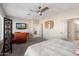 Comfortable carpeted main bedroom with ceiling fan and television at 12860 W Junipero Dr, Sun City West, AZ 85375