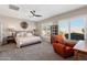 Bright and airy main bedroom featuring shutters and a comfortable chair at 12860 W Junipero Dr, Sun City West, AZ 85375