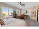 Well-lit main bedroom featuring large windows, carpeted floors, and a TV at 12860 W Junipero Dr, Sun City West, AZ 85375