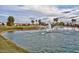Picturesque water feature with a fountain in a pond on the golf course with homes in the background at 12860 W Junipero Dr, Sun City West, AZ 85375