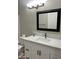 Bathroom vanity with a white countertop, modern sink, and black framed mirror above a cabinet for storage at 1444 W Spruce Dr, Chandler, AZ 85286