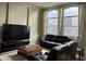 Bright living room featuring a leather sofa set, a large TV, and big windows at 1444 W Spruce Dr, Chandler, AZ 85286